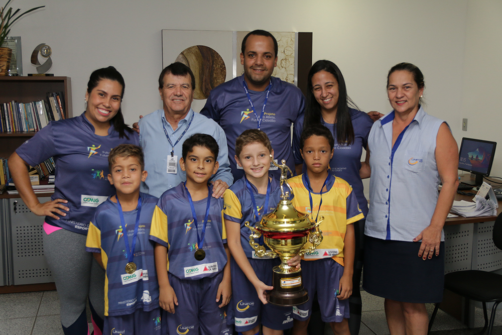 Representantes do Projeto Futuro Atleta, Futuro Cidadão entregam ao UNIFOR-MG troféu conquistado em torneio regional